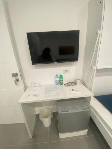 a white desk with a tv on the wall at Porta Saracena Rooms in Agropoli