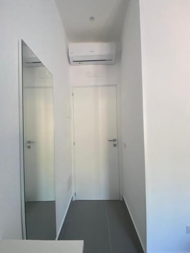a hallway with two white doors and a mirror at Porta Saracena Rooms in Agropoli