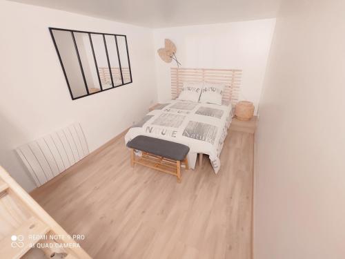 une chambre avec un lit et une chaise dedans dans l'établissement Le Petit Nogentais, à Nogent-le-Roi