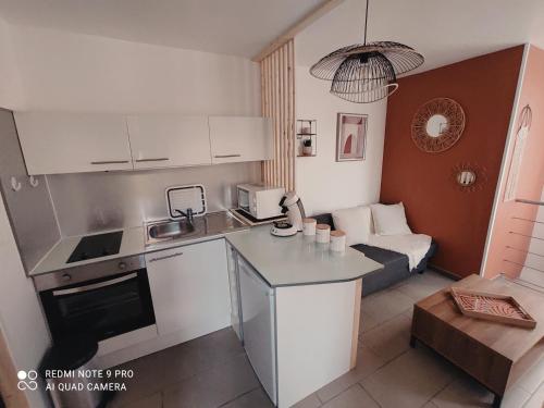 a kitchen with a counter and a couch in a room at Le Petit Nogentais in Nogent-le-Roi