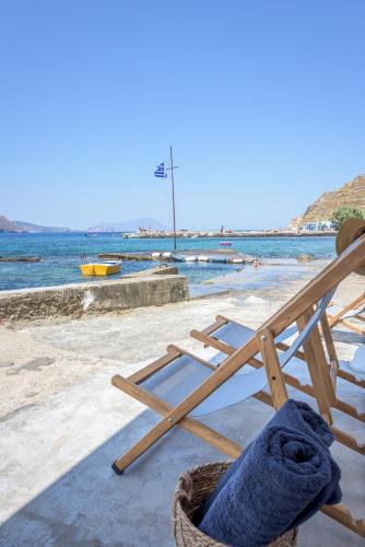 a beach chair with a towel on it next to the water at Magic Klima I in Klima