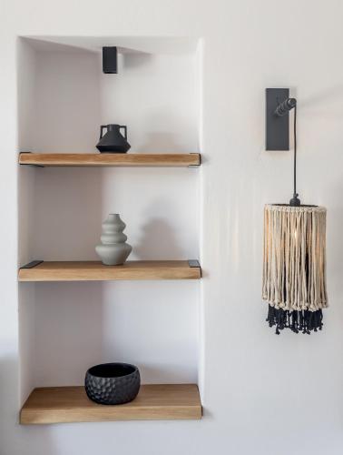 a wall with wooden shelves with a vase and a lamp at Magic Klima I in Klima