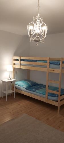 Schlafzimmer mit Etagenbett und Kronleuchter in der Unterkunft Gut Steinhügel in Bischofsmais