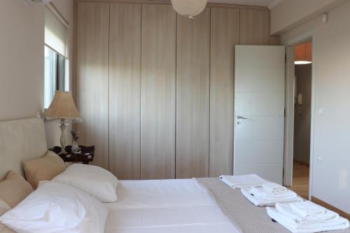 a bedroom with a white bed and a table with towels on it at Virna s home in Schinias