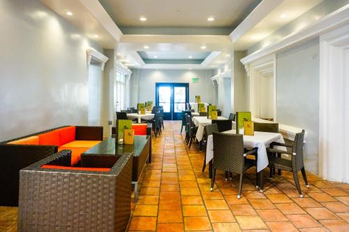 a restaurant with tables and chairs in a room at Balboa Inn, On The Beach At Newport in Newport Beach