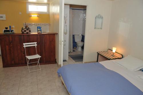 1 dormitorio con 1 cama y baño con aseo en Studio au manoir, en Saint-Jouan-des-Guérets