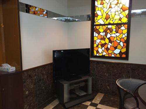 a flat screen tv with a stained glass window at アーバンホテル森下 in Tokyo