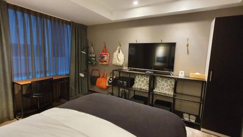 a hotel room with a bed and a flat screen tv at Yomi Hotel - ShuangLian MRT in Taipei