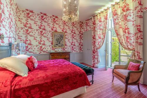 a bedroom with a red bed and floral wallpaper at La Chapelle Saint Martin in Nieul