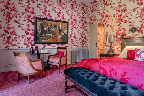 a bedroom with red wallpaper and a bed and a table at La Chapelle Saint Martin in Nieul