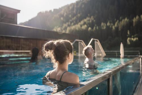 a boy and a girl in a swimming pool at Anthony's Life&Style Hotel in Sankt Anton am Arlberg