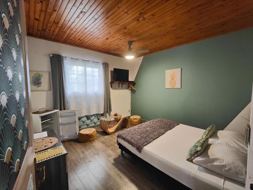 um quarto com uma cama e um tecto de madeira em Le Paille en Queue Résidence Touristique em Saint-Louis