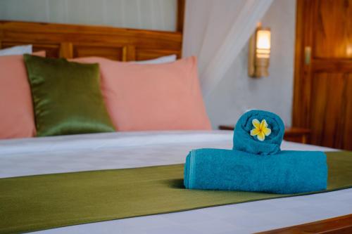 a bed with a blue box with a flower on it at Odiyana Bali Retreat in Banyuwedang