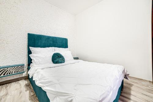 Schlafzimmer mit einem Bett mit blauem Kopfteil in der Unterkunft ARI BLUE Apart în complexul Ared Kaufland in Arad