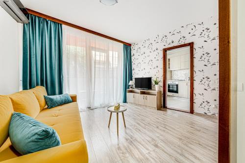 sala de estar con sofá amarillo y TV en ARI BLUE Apart în complexul Ared Kaufland en Arad