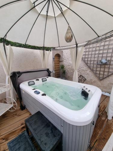 a bath tub with an umbrella in a room at Les Gîtes Mina in Mosnes