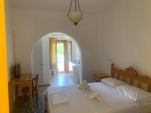 um quarto com uma cama, uma mesa e uma porta em Anixi em Astypalaia