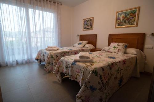 a bedroom with two beds and a window at El Rincón de Lokiz. Disfruta Navarra al natural in Galdeano