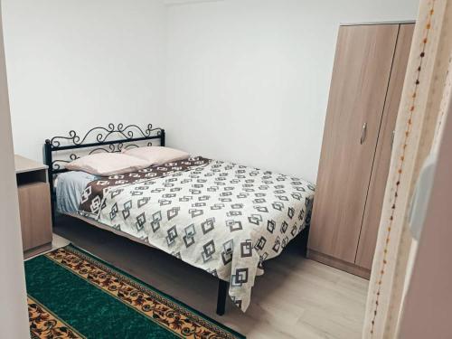 um quarto com uma cama com um edredão preto e branco em Roshel em Bosteri