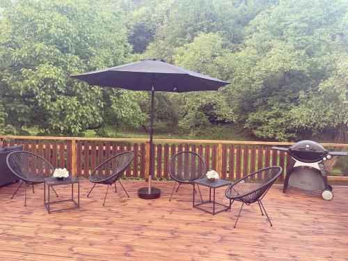 a patio with chairs and an umbrella and a grill at Guest house Mikaela in Gabrovo
