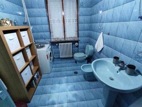 Baño azul con lavabo y aseo en Casa vacanza IL CORBETTO di Michela e Matteo, en Locana