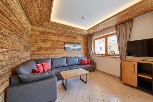 a living room with a couch and a tv at Appartements Hollandia in Saalbach Hinterglemm