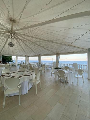 a dining room area with tables, chairs and umbrellas at Hotel Ariana in Marine du Miomo