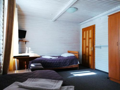 1 Schlafzimmer mit 2 Betten, einem Schreibtisch und einem Waschbecken in der Unterkunft Хостел Васкул in Kvasy