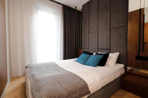 - une chambre avec un grand lit et des oreillers bleus dans l'établissement Apartament Olimpijska 116, à Olsztyn