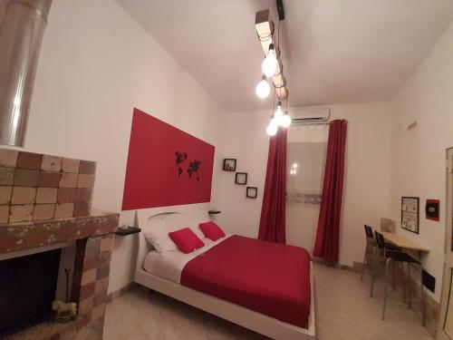 a bedroom with a bed with red sheets and a fireplace at First house in Brindisi