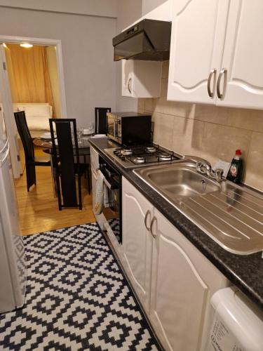 a kitchen with a sink and a stove top oven at A Beautiful place in London
