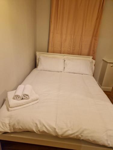 a white bed with towels on top of it at A Beautiful place in London