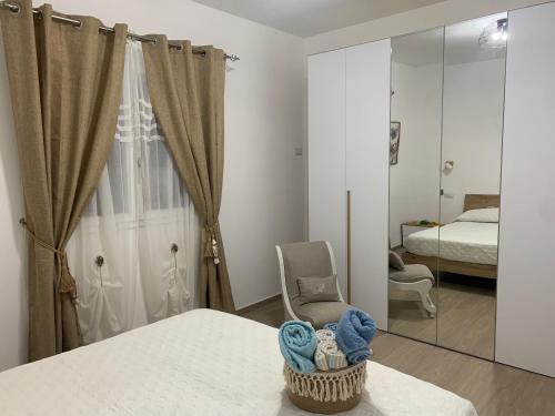 um quarto com uma cama, uma cadeira e um espelho em Appartamenti a 50 m dal mare da Cecimia's Holiday em Olbia