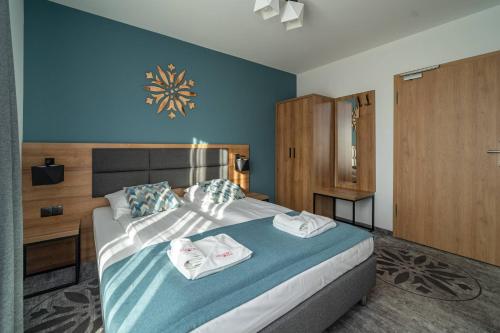 a bedroom with a large bed with towels on it at Malinowy Potok in Białka Tatrzanska