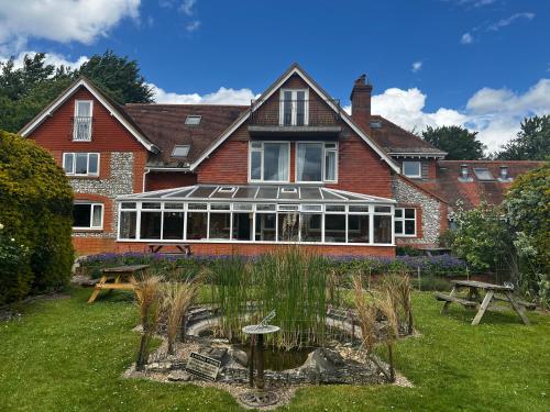 a large house with a conservatory in the yard at Stonehenge Hostel in Amesbury
