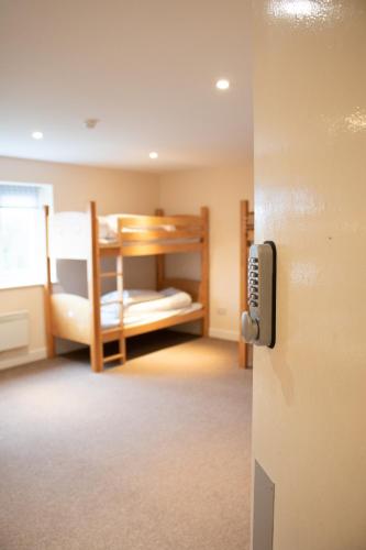 a room with a bunk bed and a room with a door at Stonehenge Hostel in Amesbury