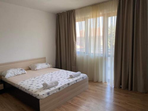 a bedroom with a bed and a large window at Петрови in Chernomorets