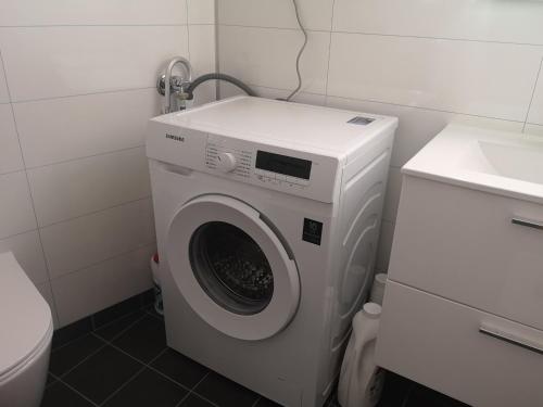 een wasmachine in een badkamer naast een toilet bij New 2 bed room apartment in Halden in Halden