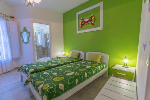 een groene slaapkamer met een bed en een groene muur bij B&B Tulip Lotus Castelbuono in Castelbuono