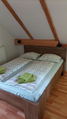 Bett mit grünem Handtuch auf einem Zimmer in der Unterkunft Vihar apartmaji in Bohinj