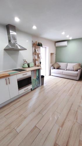 a kitchen and living room with a wooden floor at Cala Nova Studios, Vinaròs in Vinarós