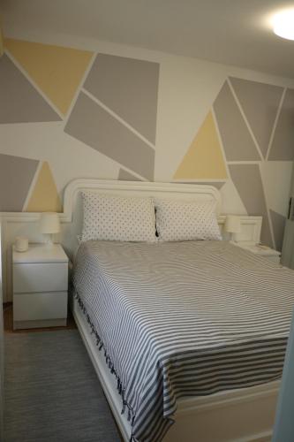 1 dormitorio con cama blanca y pared geométrica en Apartment Elize, en Zagreb