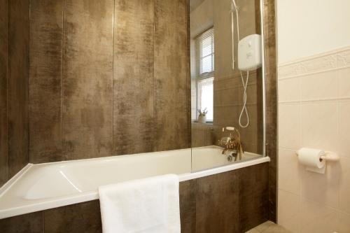 ein Badezimmer mit einer Badewanne und einem Waschbecken in der Unterkunft HAVEN HOUSE DETACHED Residence in Headingley