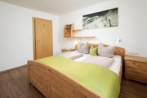 ブラームベルク・アム・ヴィルトコーゲルにあるApartment Hohe Tauernのベッドルーム1室(大型ベッド1台、緑の毛布付)