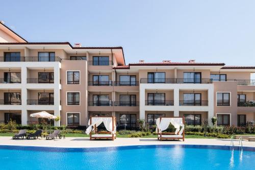 a hotel with a swimming pool and two lounge chairs at Sea Dreams Apartment in Sveti Vlas