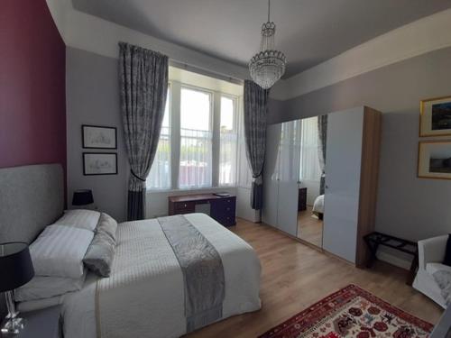 - une chambre avec un grand lit et une grande fenêtre dans l'établissement A two bedroom apartment - Victorian Villa at 8 Priestfield Road, à Édimbourg