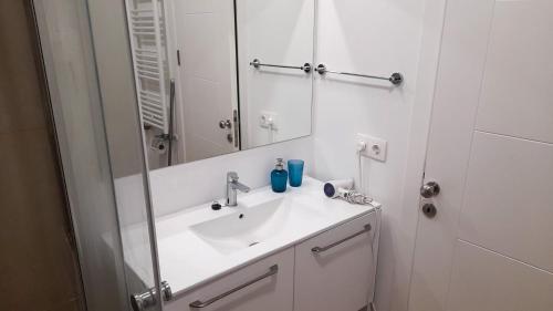 a white bathroom with a sink and a mirror at Studio Reea Olimp in Olimp