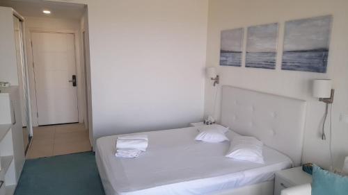 a small bedroom with a white bed with two pillows at Studio Reea Olimp in Olimp