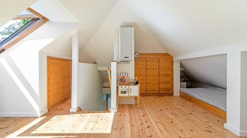 a small attic bedroom with a bed and a kitchen at VENTI Apartments Willa Sopot in Sopot