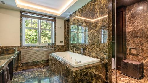 baño grande con bañera y ventana en VENTI Apartments Willa Sopot, en Sopot